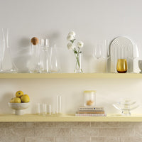 Cone shaped tall wine decanter in lead-free crystal, presented with an array of NUDE glassware products presented on a shelf with a soft white / yellow toned background